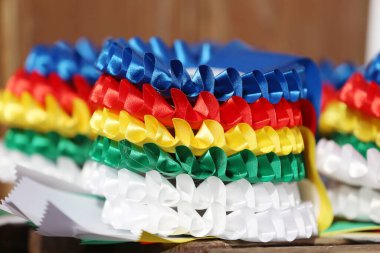 Pile of horse sport trophies rosettes at equestrian event at summertime outdoors