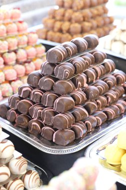 Çikolatalı badem ezmesi şekerlemeleri çeşitli tatları doldurdu. Tatlı toplar bir pastanede bir piramit gibi inşa edilir.