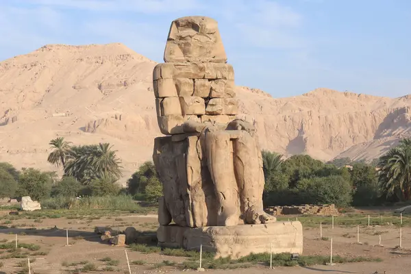 stock image Famous Colossi of Memnon. Massive ruined statues colossi of the Pharaoh Amenhotep III. Travel and tourist landmarks nearby Luxor Egypt West Bank, Thebes, Luxor,  North Africa