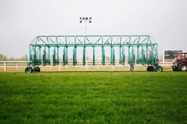 Empty horse racing starting stalls waiting for riders clipart