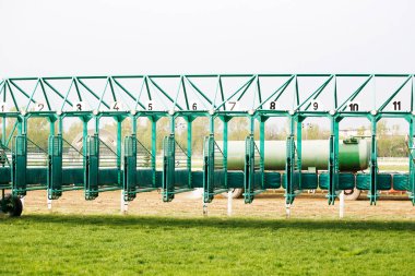 Empty horse racing starting stalls waiting for riders clipart