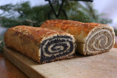 Homemade walnut and poppy seed rolls aka beigli in Hungary. Traditional hungarian christmas or easter cake bejgli at christmastime.Freshly baked sweet pies filled strudel on wooden board clipart