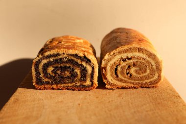 Close Up of Walnut and Poppy Seeds Rolls. Traditional Hungarian Homemade Christmas Beigli or Bejgli Cake on Wooden Board. Holiday Background clipart