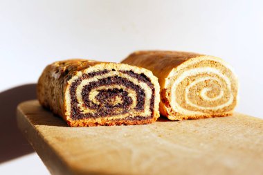 Close Up of Walnut and Poppy Seeds Rolls. Traditional Hungarian Homemade Christmas Beigli or Bejgli Cake on Wooden Board. Holiday Background clipart