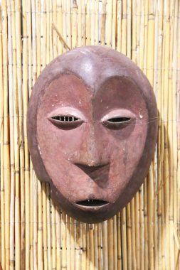 Mask carved from wood.  African tribal mask and the mask trait. Tribal mask for initiation ceremony on natural background. clipart