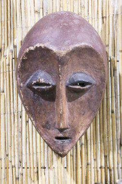 Mask carved from wood.  African tribal mask and the mask trait. Tribal mask for initiation ceremony on natural background. clipart