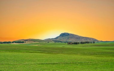 Güney Afrika, KwaZulu-Natal 'da günbatımında otlaklar ve drakensberg dağı