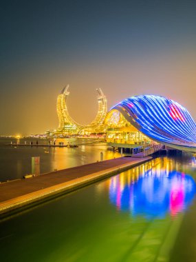 Sahildeki yeni modern binalar geceleri Lusail, Doha, Katar 'da parlıyordu.