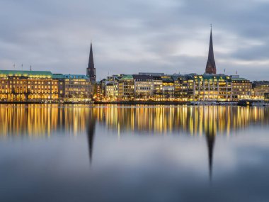 Hamburg şehrinin panoramik çekimi bir kış akşamı Binnenalster Gölü 'nde aydınlandı, Almanya