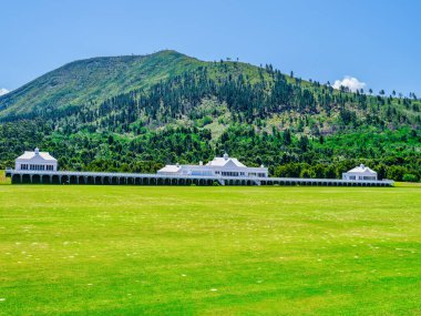 Plettenberg Körfezi 'ndeki dağın eteklerindeki polo sahası ve stadyum, Garden Route, Batı Burnu, Güney Afrika