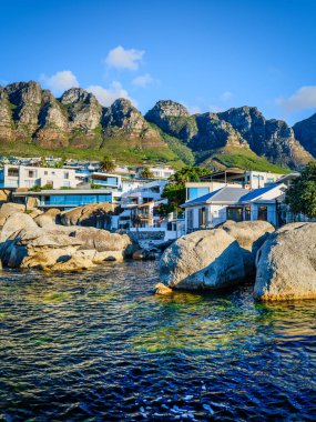 Bakbrush, Camps Bay plajı, sahil evleri ve arka planda 12 Havari dağı, Cape Town, Güney Afrika