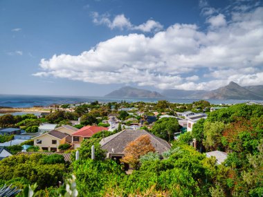 Kumsaldaki Kommetjie kasabası mavi gökyüzü beyaz bulutlar altında, Cape Town, Güney Afrika