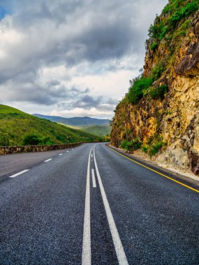 Vertical shot of winding road with lines in the Langeberg Mountains leading to Tradouw Pass, Suurbraak, Overberg, Western Cape, South Africa clipart