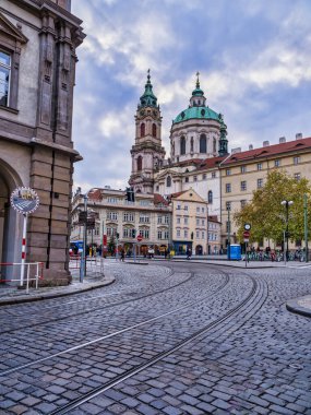 Çek Cumhuriyeti 'nin bulutlu bir döneminde Prag asfalt caddesi ve Saint Francis Assisi Kilisesi' nin kubbesi