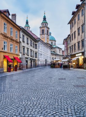 Slovenya 'nın eski Ljubljana kasabasında Noel boyunca Cobblestone Caddesi ve Katedral Kulesi