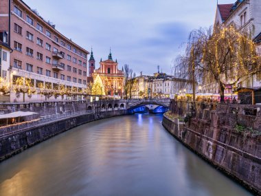 Ljubljana Nehri yan sokağı alacakaranlıkta Noel ışıklarıyla aydınlanıyor, Slovenya