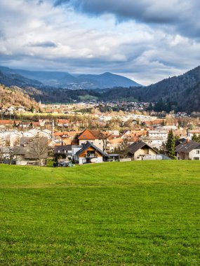 Sloven Kamnik köyü vadisi ve dağının dramatik bir bulut gökyüzü sırasında kayan tepeleriyle dikey görüntüsü