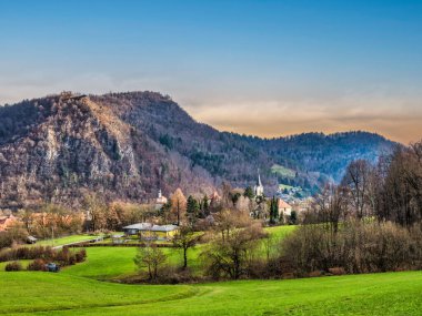 Parlak yeşil tepeler ve arka planda dağ olan St Joseph kilise kulesi, Kamnik köyü, Slovenya