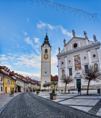 Cobblestone Sutna sokağı ve Cerkveni kilise kulesini mavi gökyüzü öğleden sonra, Kamnik, Slovenya