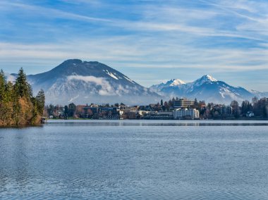 Lakeside kasaba binaları ve kar zirvesi dağları kış öğleden sonra, Bled, Slovenya