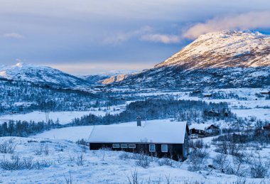 Norveç 'in başkenti Eidfjord' da güneş batarken karla kaplı geleneksel Norwegen ahşap kılıfları