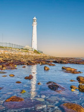 Slangkop Deniz feneri ve açık bir öğleden sonra deniz suyundaki yansıması, Kommetjie, Cape Town, Güney Afrika