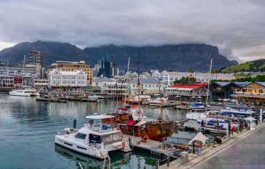 V ve A Waterfront ve arka plandaki masa dağı bulutlu bir akşamda, Cape Town, Güney Afrika