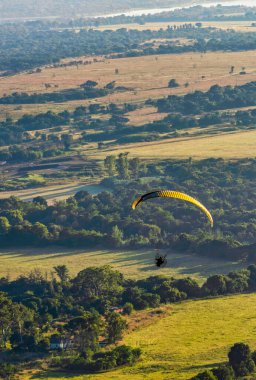 Gündoğumu sırasında Magaliesburg Vadisi üzerinde uçan güçlü paraglider, Gauteng, Güney Afrika