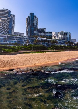 Okyanus manzaralı umhlanga sahil binaları, altın bulutlar ve mavi su