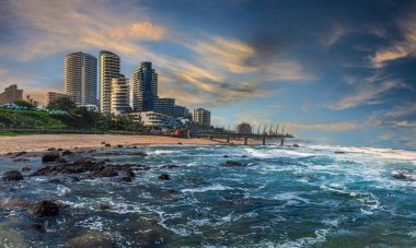 Okyanus manzaralı umhlanga sahil binaları, altın bulutlar ve mavi su