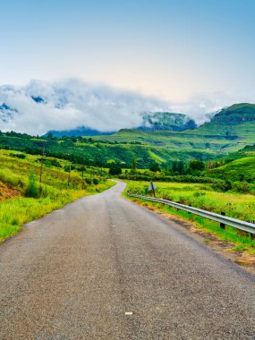 Drakensberg vadisinde Catkin Tepesi, KwaZulu-Natal, Güney Afrika 'ya giden virajlı kırsal bir yolun dikey çekimi.