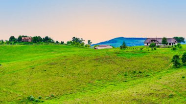 Drakensberg village houses on a hilltop during sunset, showcasing the scenic and tranquil landscape, KwaZulu-Natal, South Africa clipart