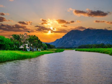 Klein Nehri 'ndeki evler dramatik bir günbatımı gökyüzü, Stanford, Western Cape, Güney Afrika