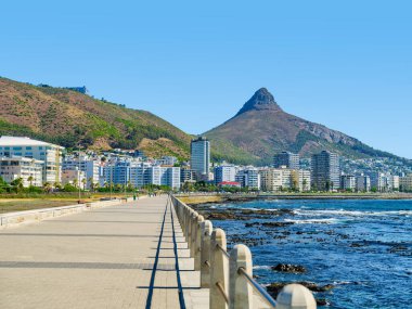 Canlı Sea Point Gezinti Alanı ve parıldayan Atlantik Okyanusu sahnesi, arka planda belirgin Aslan Başı Dağı, Cape Town, Güney Afrika