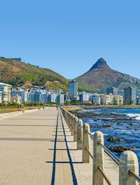 Canlı Deniz Noktası Gezintisi ve parıldayan Atlantik Okyanusu dikey görünümü, arka planda belirgin Aslan Başı Dağı, Cape Town, Güney Afrika