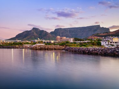 A long exposure view of Table Mountain and the vibrant Waterfront area captured from Mouille Point during twilight in Cape Town, South Africa. clipart