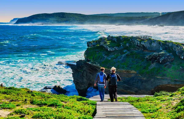 Bir çift, güzel Robberg Yarımadası Doğa Rezervi, Plettenberg Körfezi, Güney Afrika 'nın ahşap geçitlerinde yürüyüş yaparken manzaranın tadını çıkarıyor.