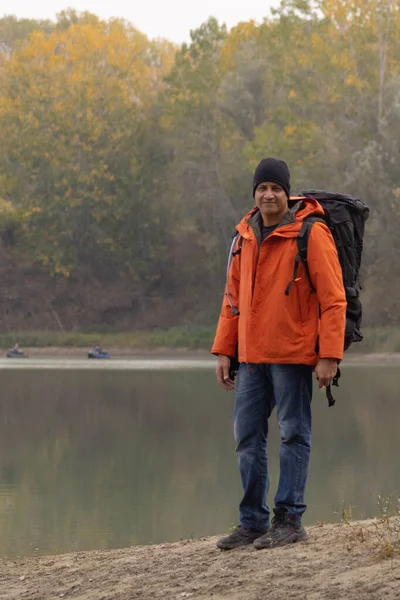 Portrait of traveler man at lake in autumn. High quality photo