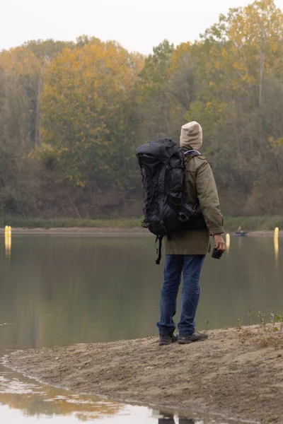 Portrait of traveler man at lake in autumn. High quality photo