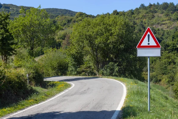 Mountain road with warning sign, Toscano Emiliano Park in Parma province, Italy. High quality photo