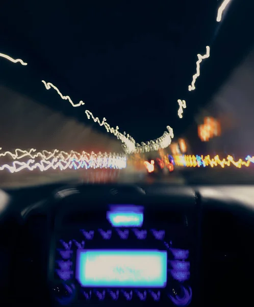 Gece tüneli ve titreyen ışıkları hareket halindeki bir arabanın içinden görülebiliyor.