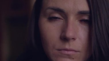 Kameraya bakan ciddi beyaz kızın yakın görüntüsü. Düşük ışıktaki hüzünlü bin yıllık kadın portresi. İnsanlar ve duygular kavramı..