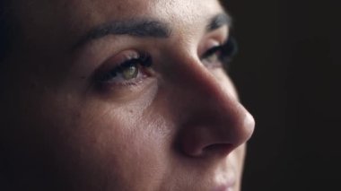 Kadının yüzüne yakın çekim. Çekici kız güzel yeşil gözlerini açıyor. Doğal makyajlı ve uzun kirpikli genç bir bayan model. Yavaş çekim HD görüntüler