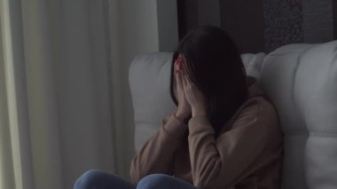 Hüsrana uğramış biri yerde oturup duygusal acıdan acı çekiyor. Bunalımda olan endişeli genç bir kadın