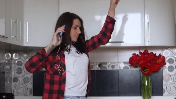 Счастливая Молодая Женщина Танцует Кухне Слушая Музыку Смартфоне Наушниками — стоковое видео