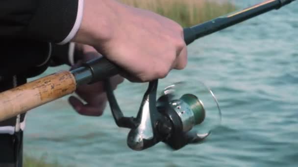 Κλειστά Χέρια Του Ψαρά Κρατούν Καλάμι Ψαρέματος Ένας Ψαράς Ψαρεύει — Αρχείο Βίντεο
