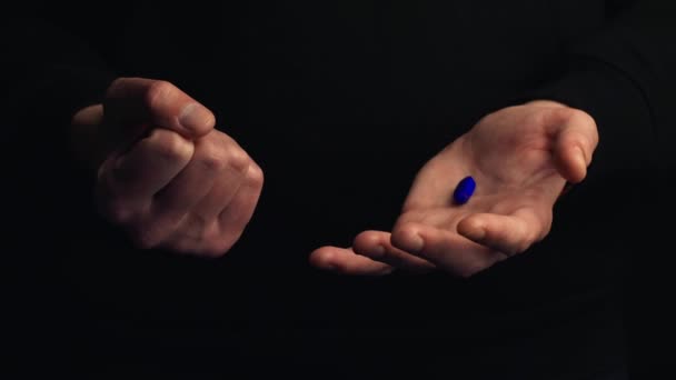 スタジオ撮影男性の手は黒の背景に隔離された青い丸薬を示しています 正しい選択をするという概念 シネマティック4K映像 — ストック動画