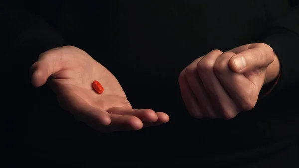 Studioaufnahmen Männlicher Hände Zeigen Rote Pille Isoliert Auf Schwarzem Hintergrund Stockfoto