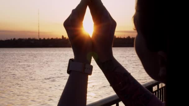 Flickan Fångar Solljuset Med Händerna Vid Solnedgången Solens Ljus Passerar — Stockvideo