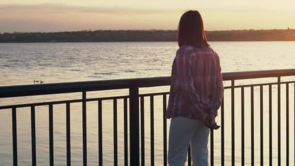Seorang Wanita Kesepian Berdiri Tanggul Sungai Kota Saat Matahari Terbenam — Stok Video